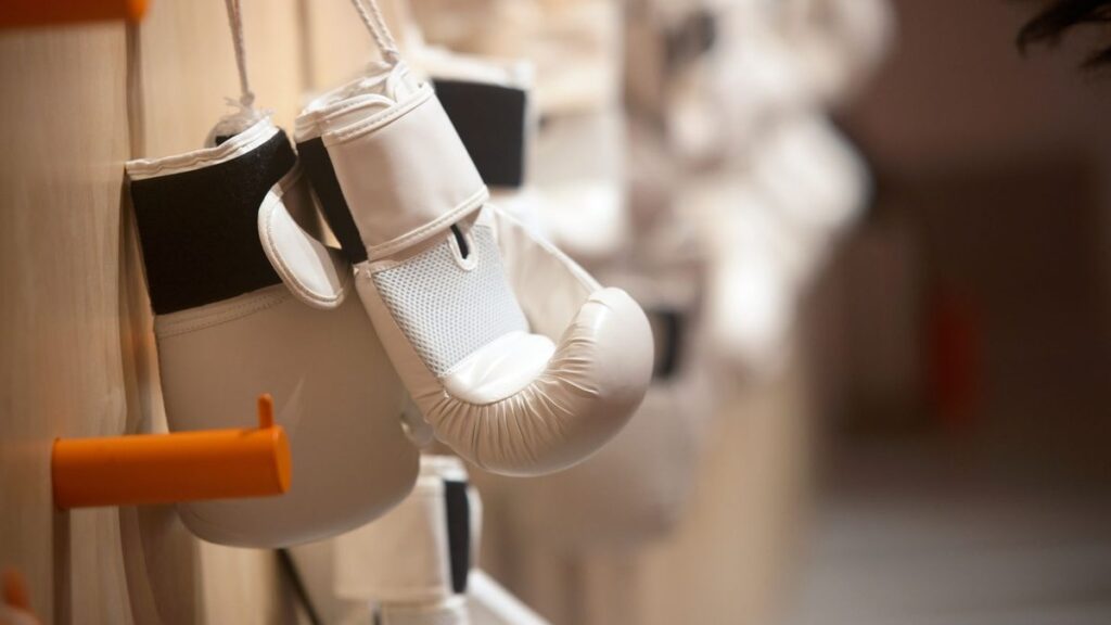 Gants de boxe blancs suspendus à un support dans une salle