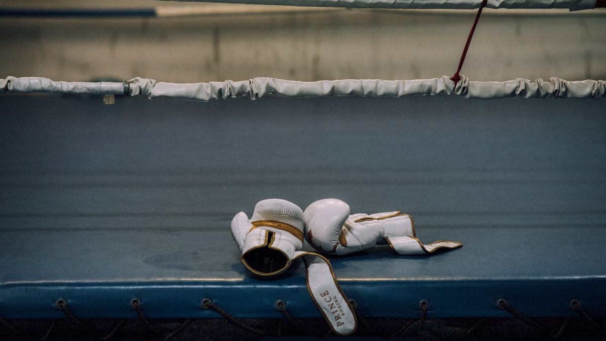 Gants de boxe posés sur le tablier d'un ring désert